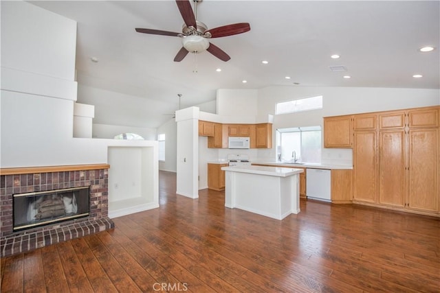 kitchen featuring dark wood-type flooring, white appliances, sink, and a kitchen island