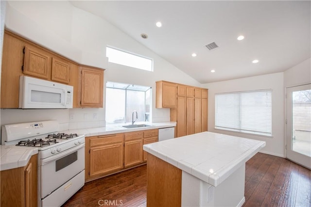 kitchen with sink, white appliances, dark wood-type flooring, tile counters, and a kitchen island