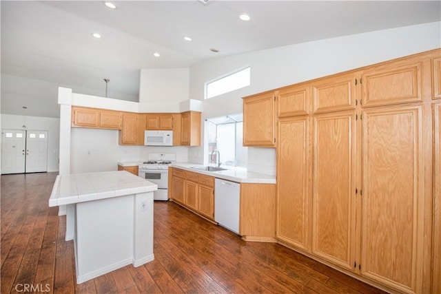 kitchen featuring dark wood-type flooring, white appliances, a center island, and sink