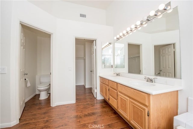 bathroom with vanity, hardwood / wood-style flooring, and toilet