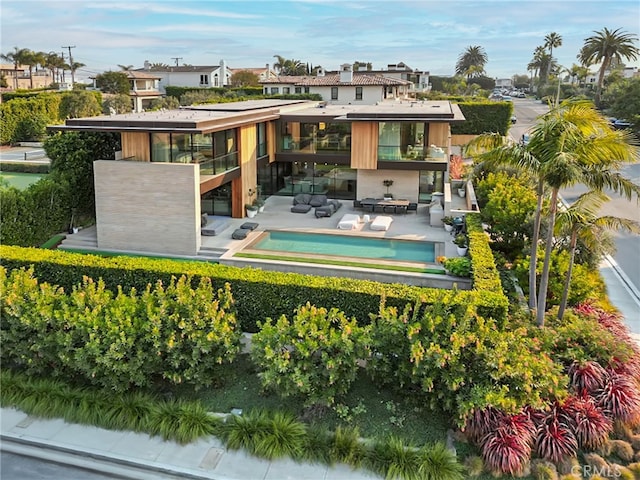 back of property featuring a hot tub, a patio, and an outdoor living space