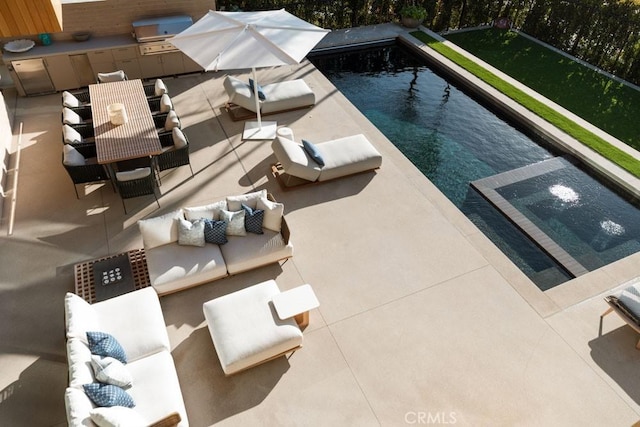 view of swimming pool with an outdoor living space, grilling area, a patio, and exterior kitchen
