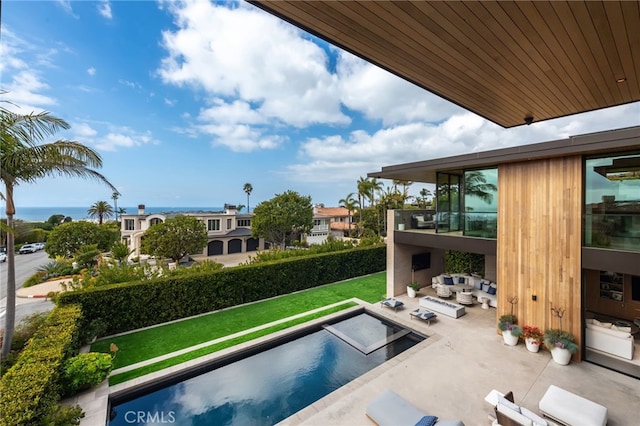 view of swimming pool with outdoor lounge area, a patio area, and a lawn