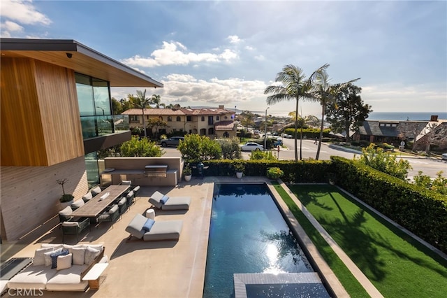 view of pool featuring exterior kitchen and a patio area