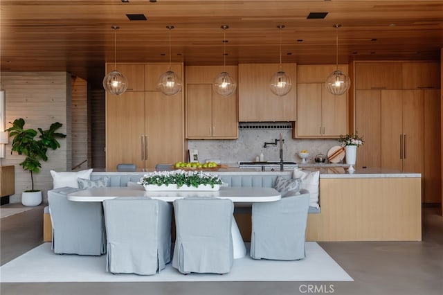 kitchen with light brown cabinetry, extractor fan, decorative light fixtures, concrete floors, and wooden ceiling