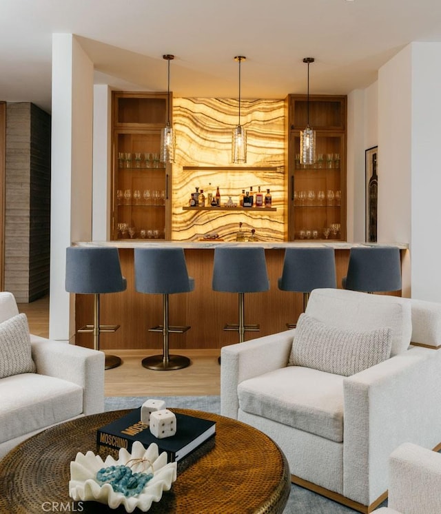 bar featuring hardwood / wood-style floors and hanging light fixtures