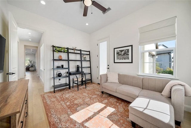 living room featuring light hardwood / wood-style flooring and ceiling fan