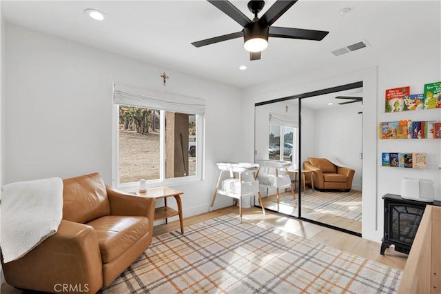 sitting room with ceiling fan, a healthy amount of sunlight, and light wood-type flooring