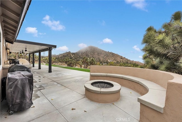 view of patio featuring area for grilling, an outdoor fire pit, and a mountain view