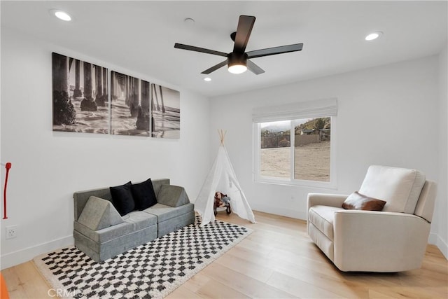 living room with ceiling fan and light wood-type flooring