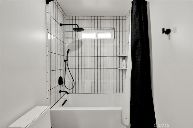 bathroom featuring tiled shower / bath and toilet