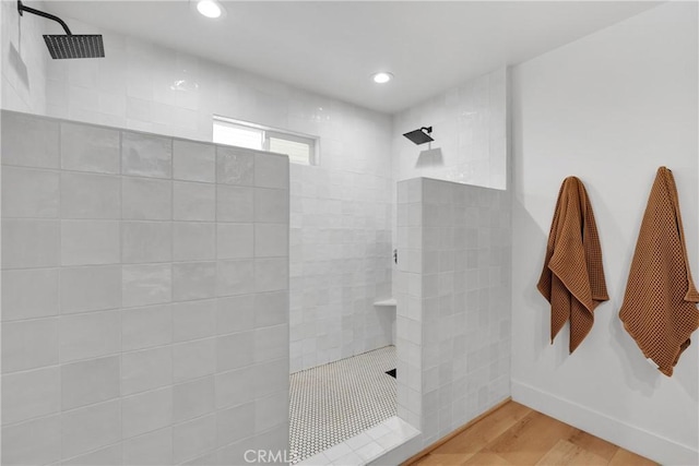 bathroom featuring hardwood / wood-style flooring and tiled shower