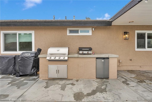 view of patio / terrace featuring an outdoor kitchen and a grill