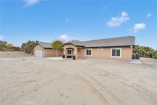 view of front of property featuring a garage and cooling unit