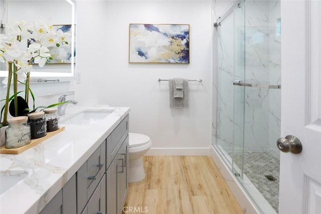 bathroom with vanity, wood-type flooring, an enclosed shower, and toilet