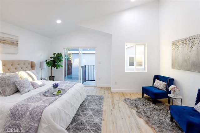 bedroom with access to exterior, light hardwood / wood-style floors, and vaulted ceiling