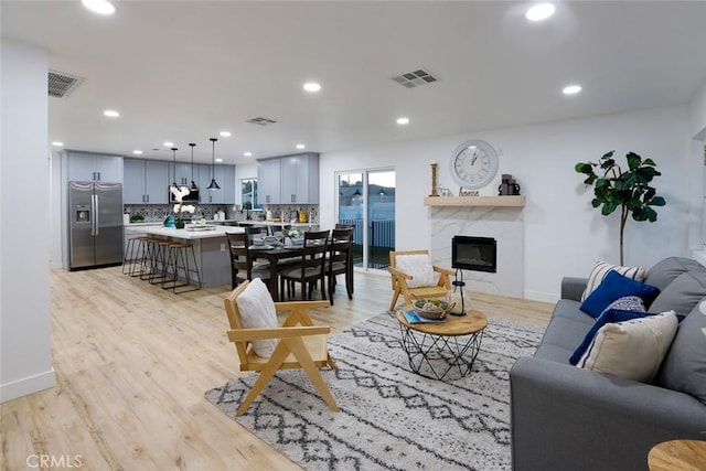 living room featuring a premium fireplace and light hardwood / wood-style flooring