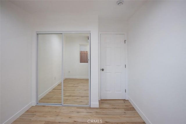 unfurnished bedroom featuring a closet and light wood-type flooring