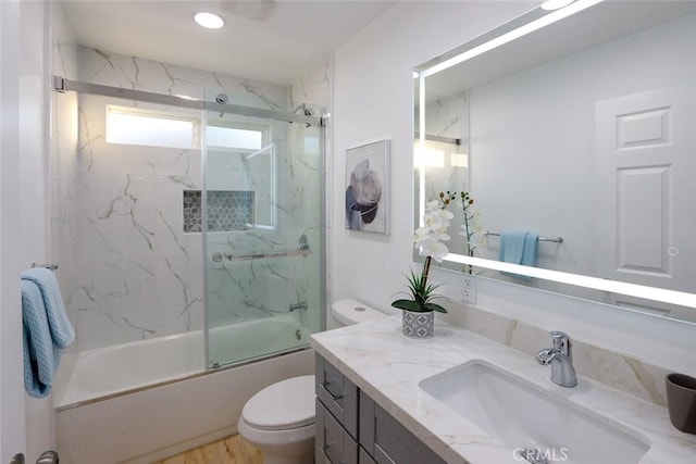 full bathroom featuring vanity, enclosed tub / shower combo, and toilet