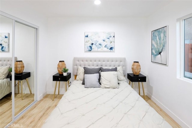 bedroom with wood-type flooring and a closet