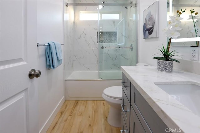 full bathroom featuring wood-type flooring, vanity, shower / bath combination with glass door, and toilet