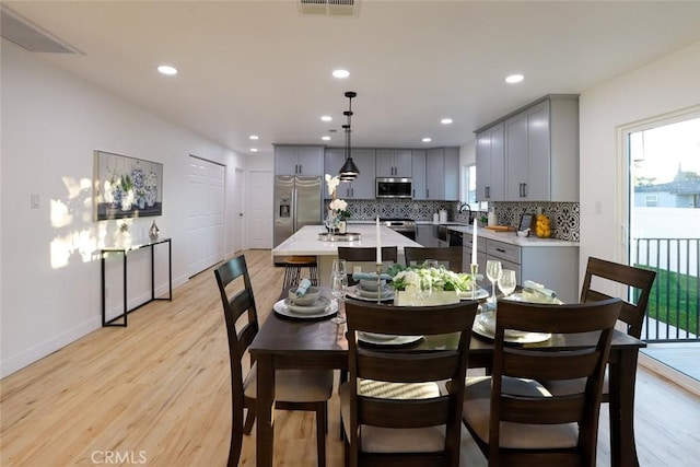 dining space featuring sink and light hardwood / wood-style floors