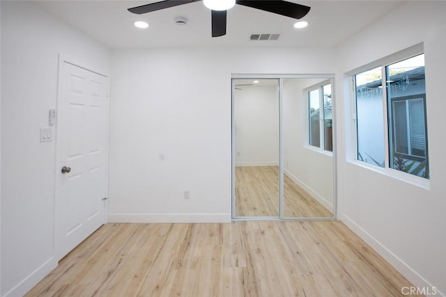 unfurnished bedroom with ceiling fan, a closet, and light hardwood / wood-style flooring