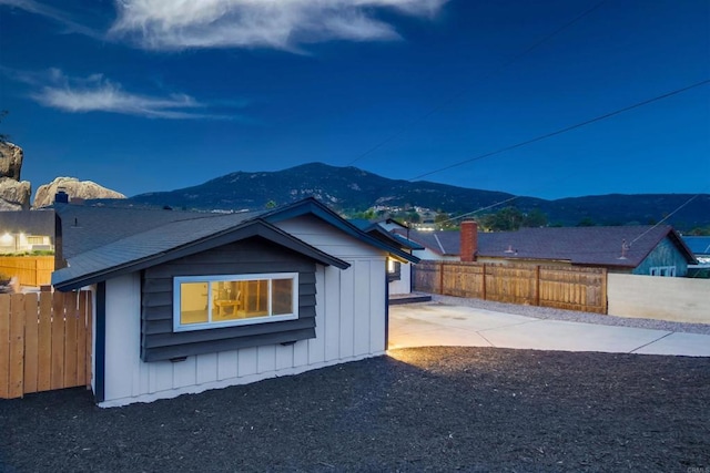 view of side of property featuring a mountain view and a patio