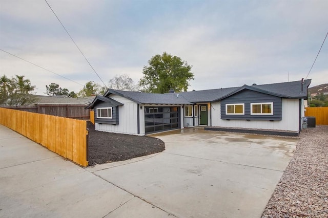 ranch-style house featuring a garage and central air condition unit