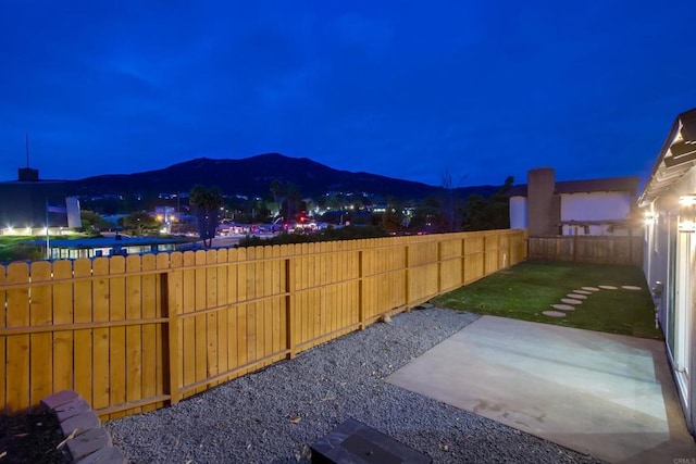 yard at night featuring a patio and a mountain view