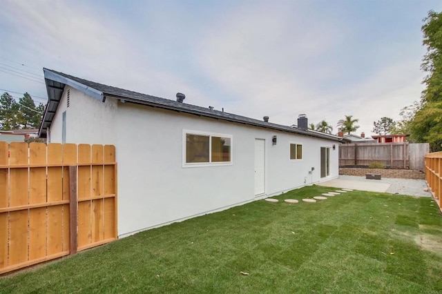 rear view of property featuring a lawn and a patio