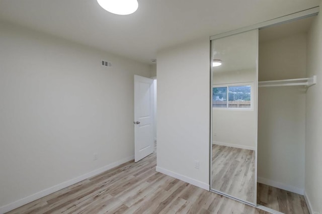 unfurnished bedroom featuring a closet and light wood-type flooring