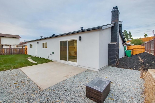 rear view of property featuring a yard and a patio