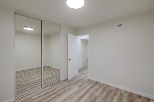 unfurnished bedroom with light hardwood / wood-style floors and a closet