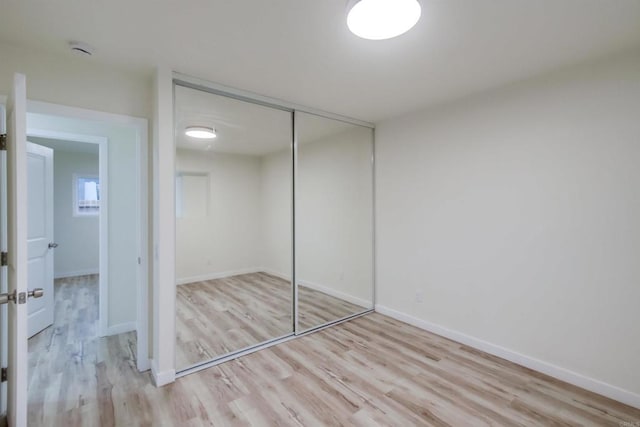 unfurnished bedroom with a closet and light hardwood / wood-style flooring