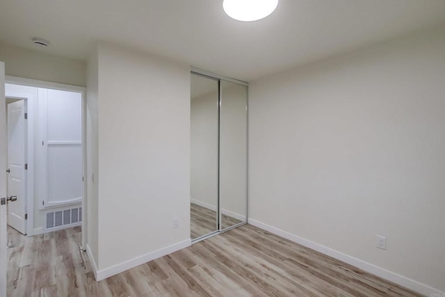 unfurnished bedroom with a closet and light hardwood / wood-style flooring