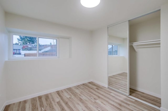 unfurnished bedroom featuring light hardwood / wood-style floors and a closet