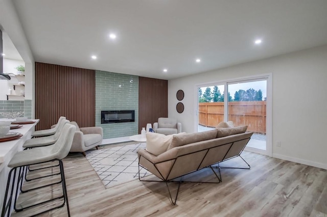 living room featuring a large fireplace and light wood-type flooring