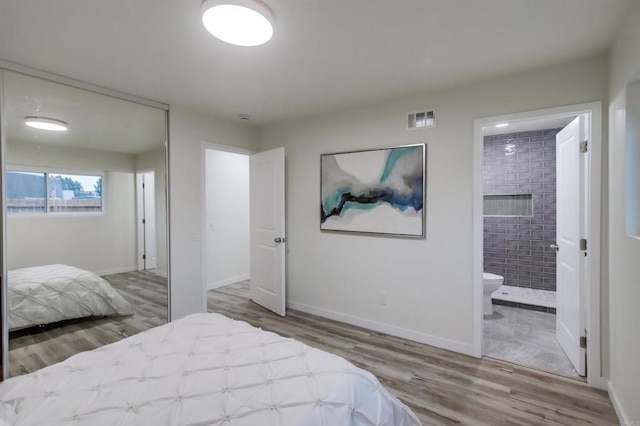 bedroom featuring wood-type flooring and connected bathroom