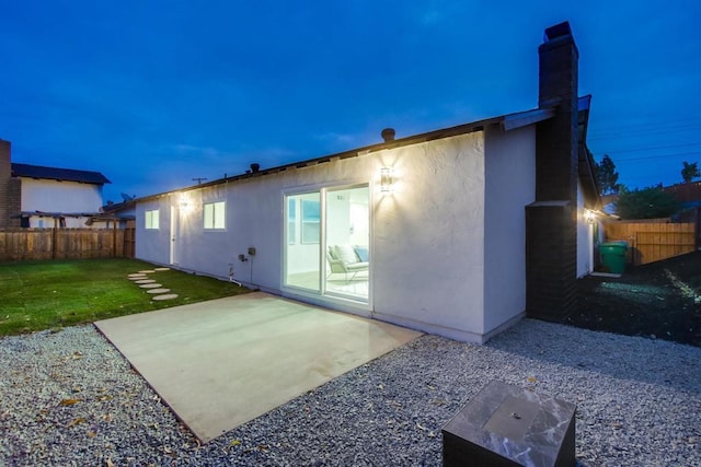 back of house featuring a lawn and a patio area