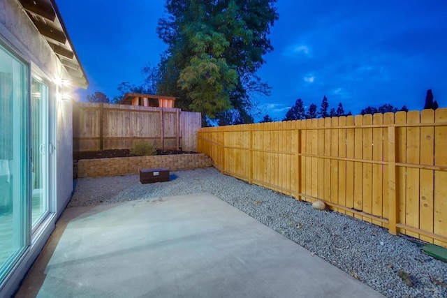 yard at dusk featuring a patio area