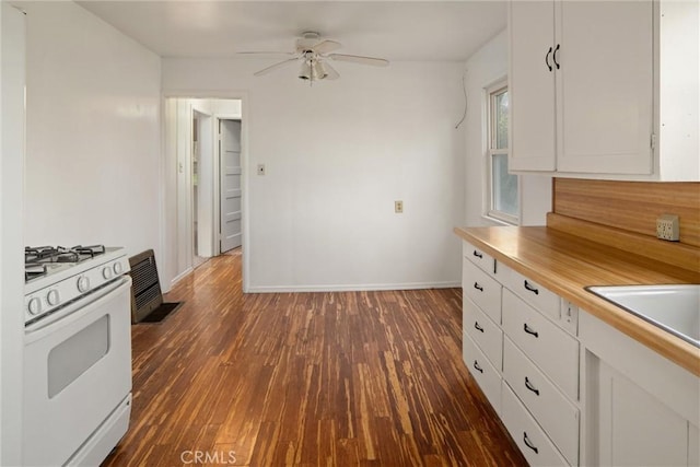 kitchen featuring sink, ceiling fan, white range with gas stovetop, white cabinetry, and dark hardwood / wood-style flooring