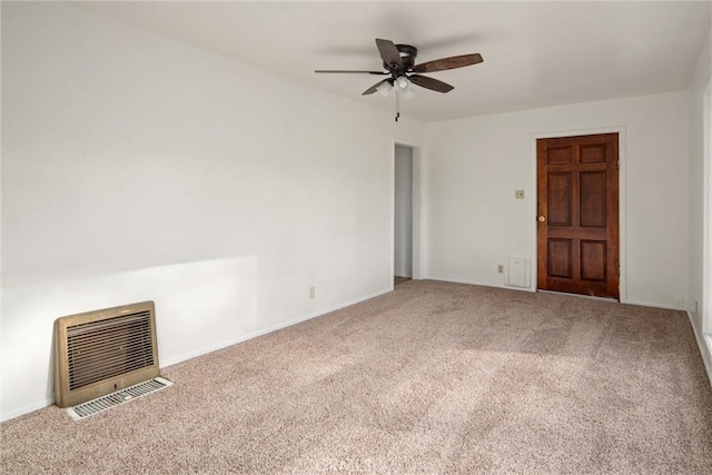 carpeted empty room featuring heating unit and ceiling fan