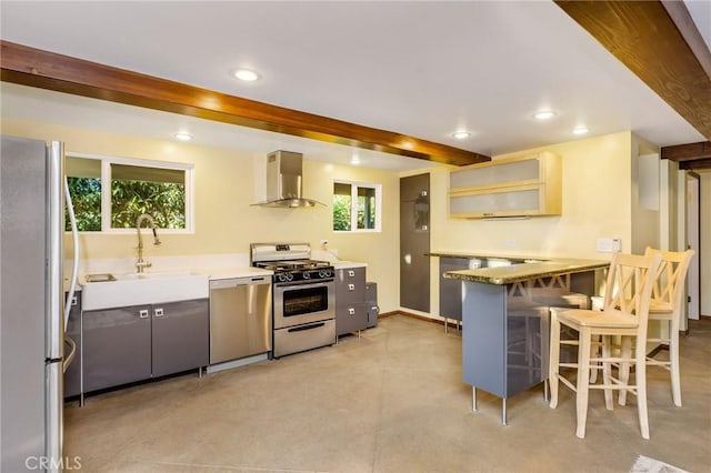 kitchen featuring beam ceiling, recessed lighting, appliances with stainless steel finishes, and wall chimney range hood