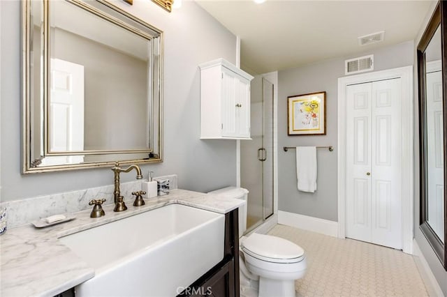 full bathroom featuring vanity, a shower stall, toilet, and visible vents