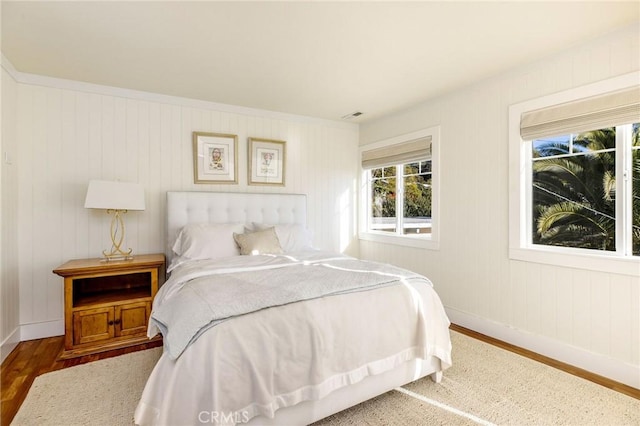 bedroom with wood finished floors and baseboards