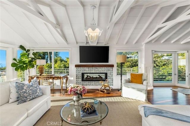 sunroom with a tile fireplace and vaulted ceiling with beams