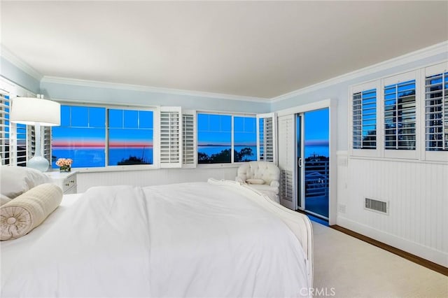 bedroom with visible vents, crown molding, a water view, and wood finished floors