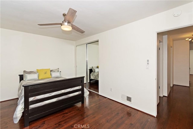 bedroom with dark hardwood / wood-style flooring, a closet, and ceiling fan