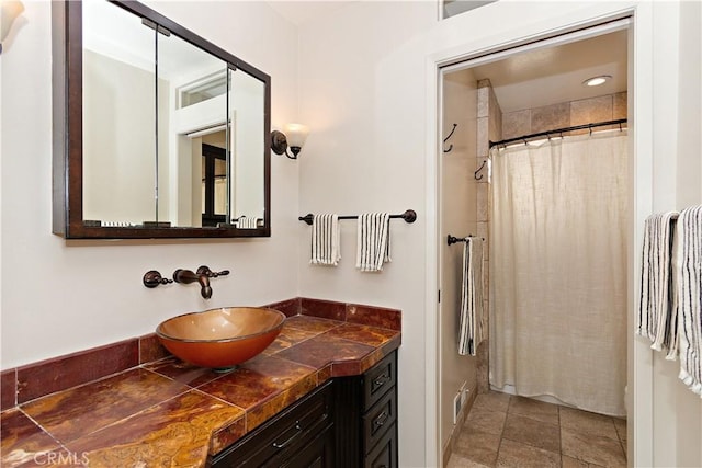 bathroom featuring tile patterned flooring, vanity, and walk in shower